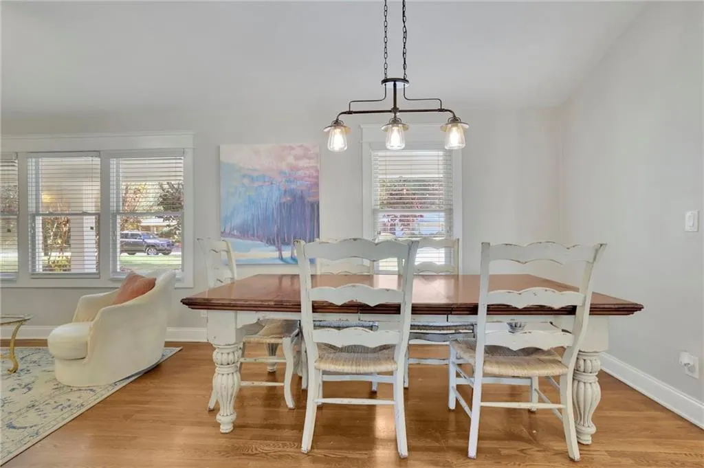 Dining area with light hardwood / wood-style flooring, a healthy amount of sunlight, and an inviting chandelier