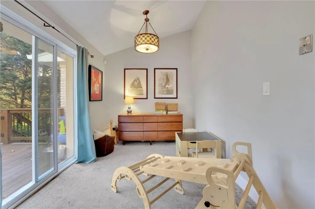 Sitting room with light carpet and lofted ceiling