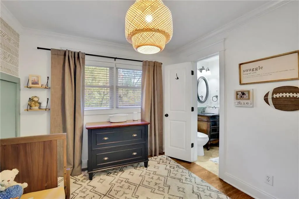 Bedroom featuring connected bathroom, light hardwood / wood-style floors, crown molding, and sink