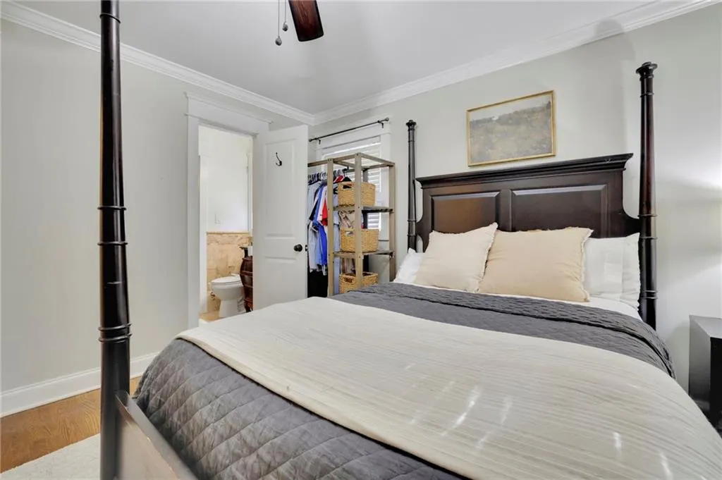 Bedroom featuring connected bathroom, ceiling fan, crown molding, and hardwood / wood-style flooring