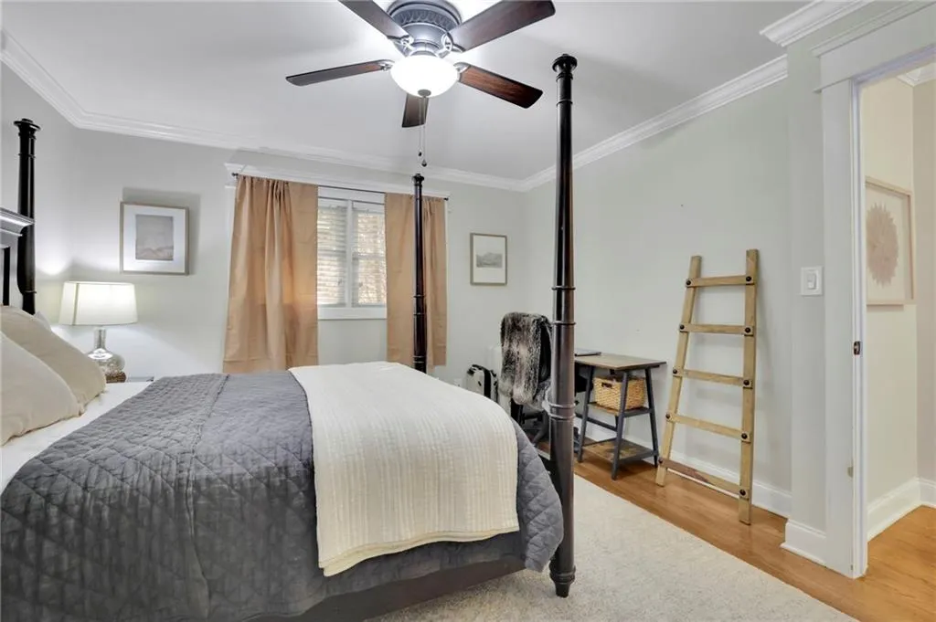 Bedroom featuring hardwood / wood-style floors, ceiling fan, and crown molding