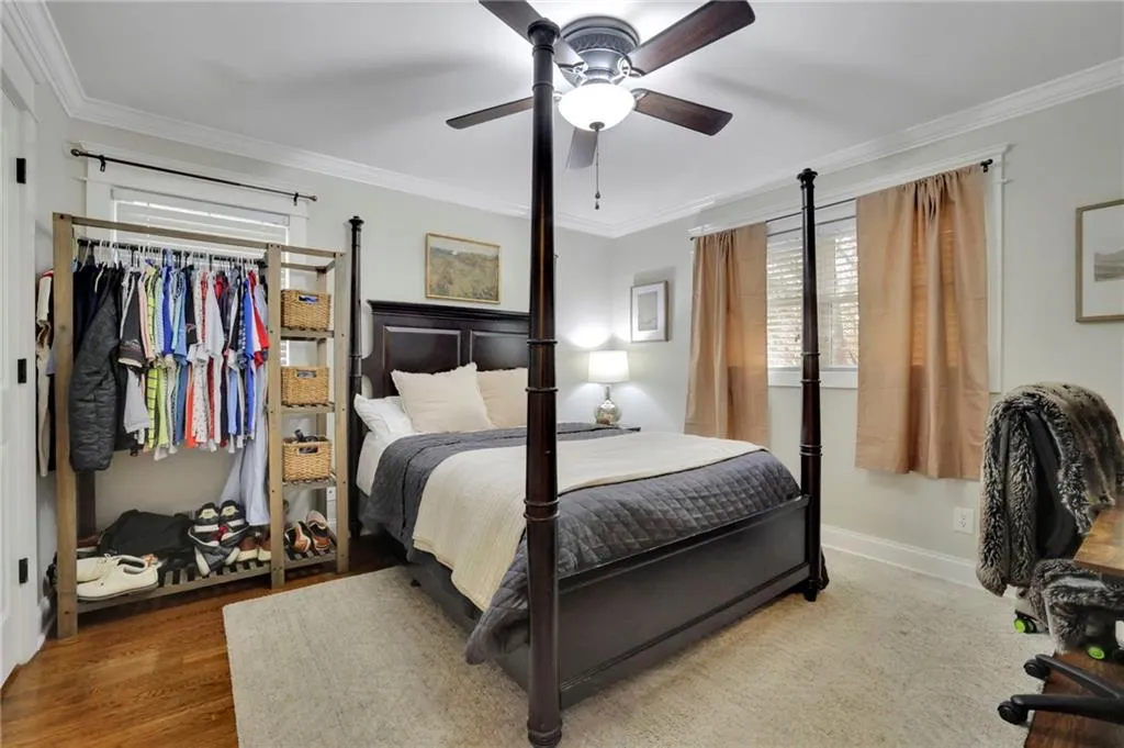 Bedroom with hardwood / wood-style flooring, ceiling fan, and ornamental molding