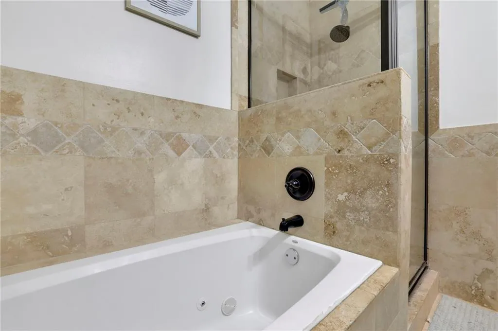 Bathroom featuring shower with separate bathtub