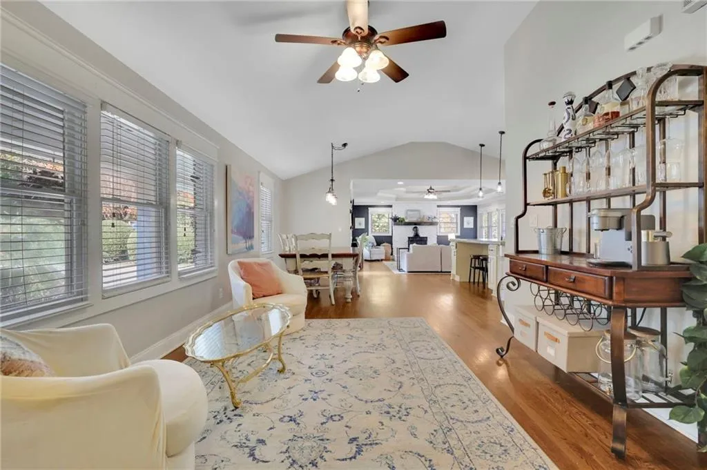 Living room featuring ceiling fan, lofted ceiling, and hardwood / wood-style flooring