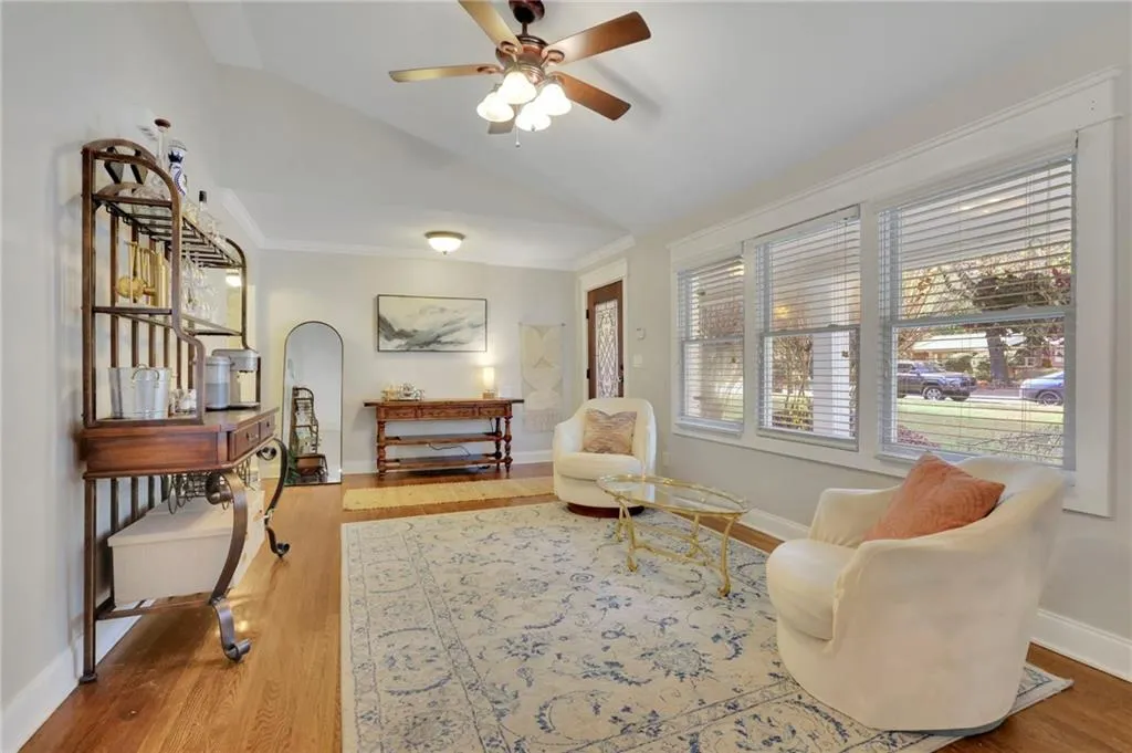 Sitting room featuring hardwood / wood-style flooring, vaulted ceiling, ceiling fan, and crown molding