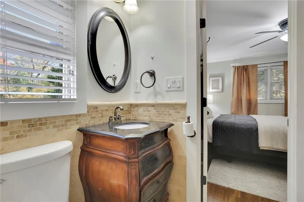 Bathroom featuring vanity, ceiling fan, crown molding, wood-type flooring, and toilet