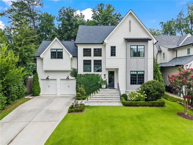 Modern Colonial estate featuring a crisp white exterior with black-trimmed windows and a gabled roofline