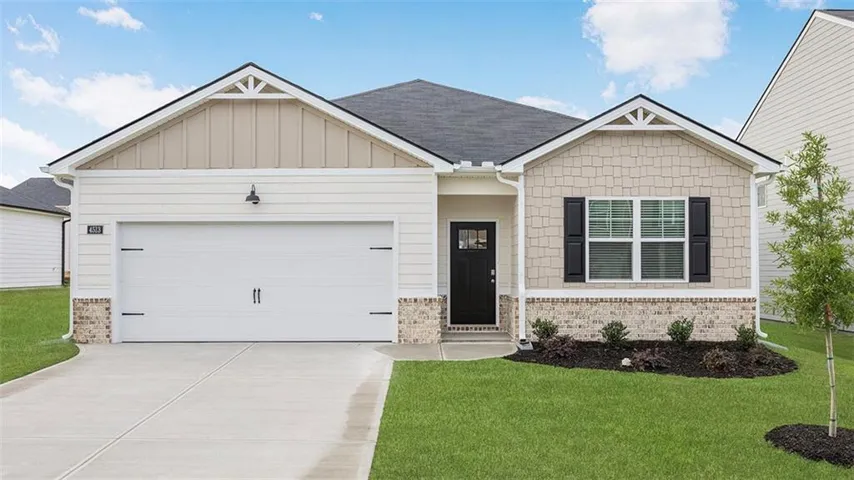 Single-story residence featuring a two-car garage, mixed siding and brick facade, a covered entry, and front yard landscaping
