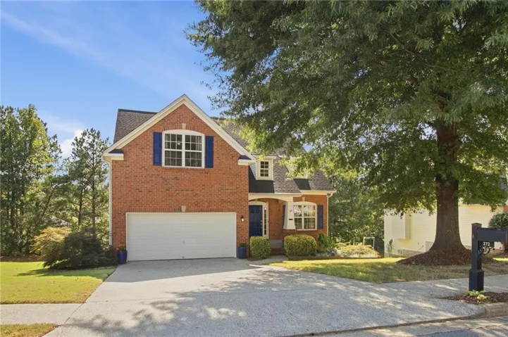 Brick exterior, attached garage, white garage door, blue exterior shutters, dormer window