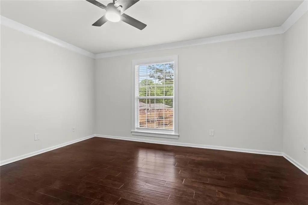 West facing bedroom with fresh paint, crown molding and new ceiling fan/light fixture