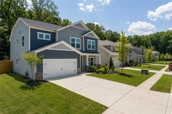 Contemporary two-story residence featuring a two-tone facade, stone accents, and a two-car garage