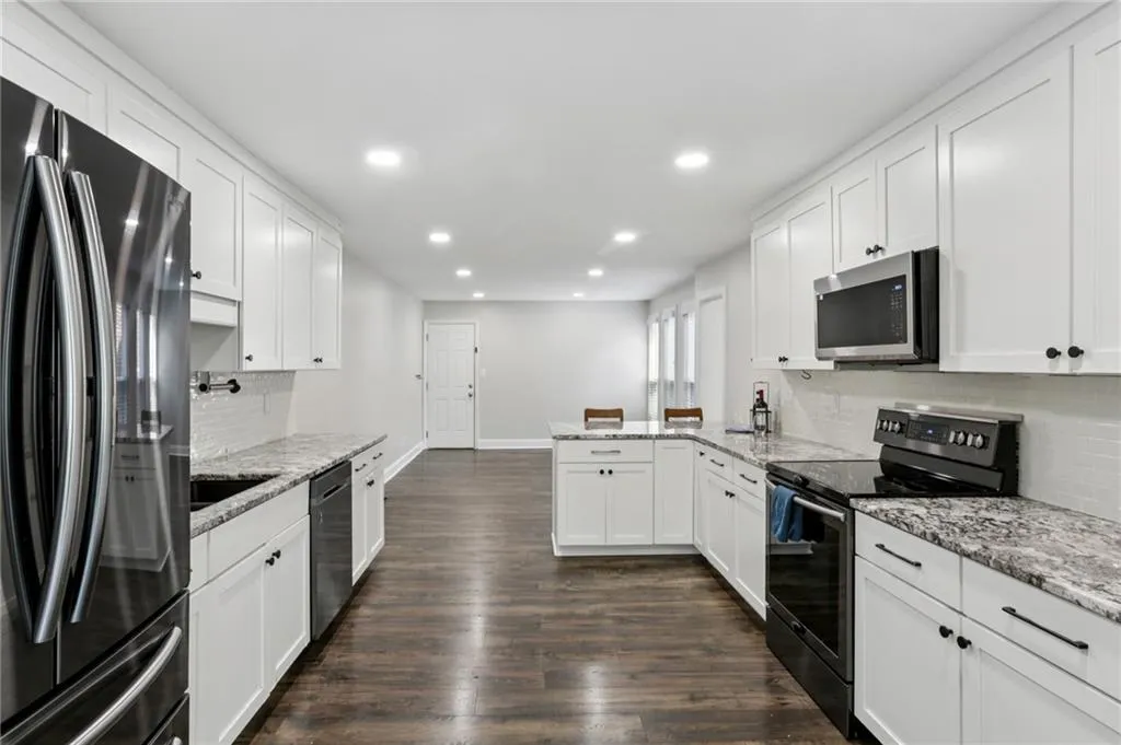 Classic white kitchen with updates including a brand new microwave.  Hardwood floors.  Opens to breakfast room and adjoining garage.