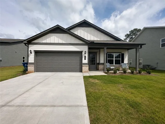 Contemporary single-story residence featuring a covered front porch, a two-car garage, and a concrete driveway
