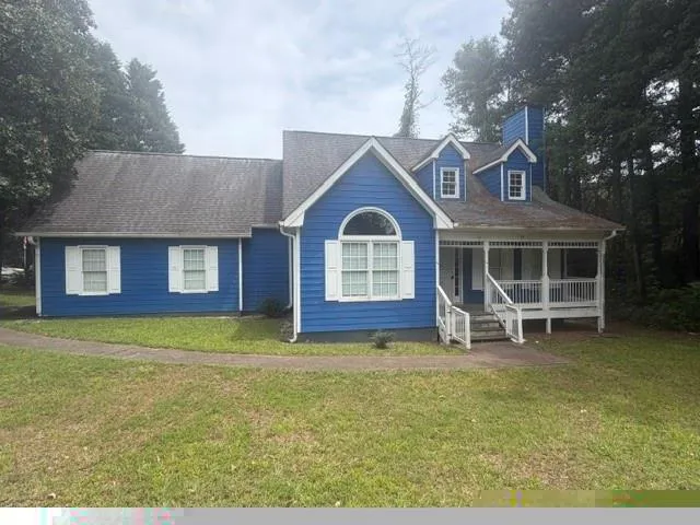Blue siding exterior with white window shutters and a covered front porch featuring white railings