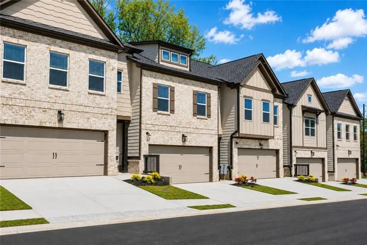 Modern townhome exteriors featuring light brick and beige siding