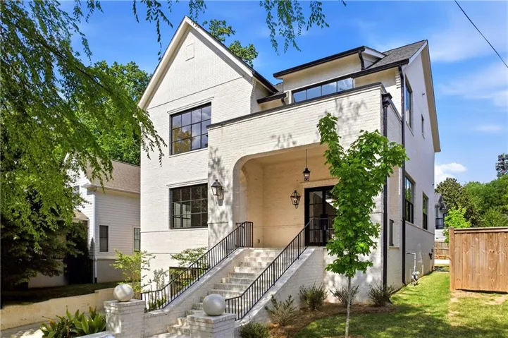 Modern architectural design featuring white brick siding, a prominent gabled roofline, and black-framed windows