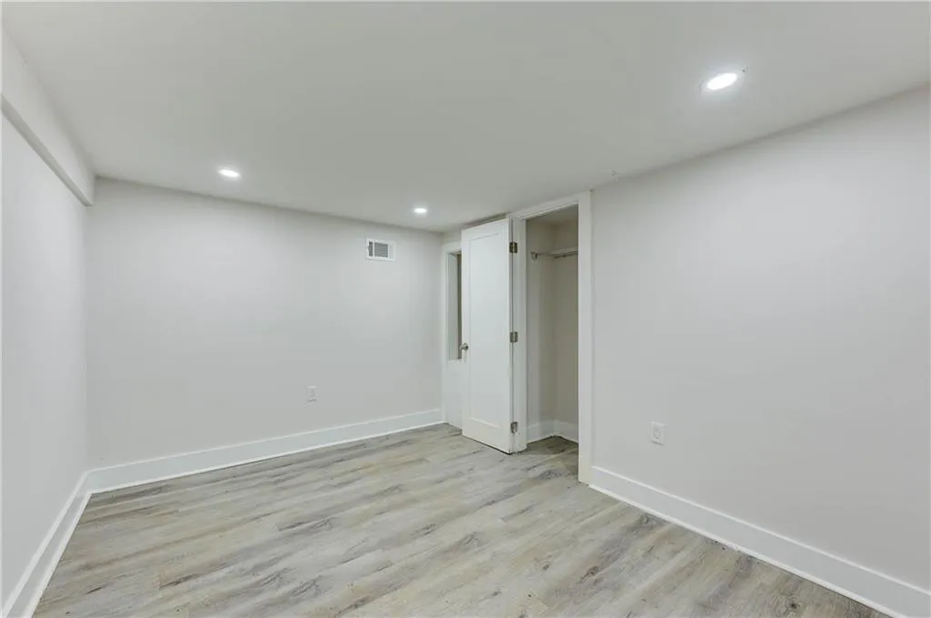 Unfurnished bedroom with light wood-style floors, recessed lighting, and a walk in closet