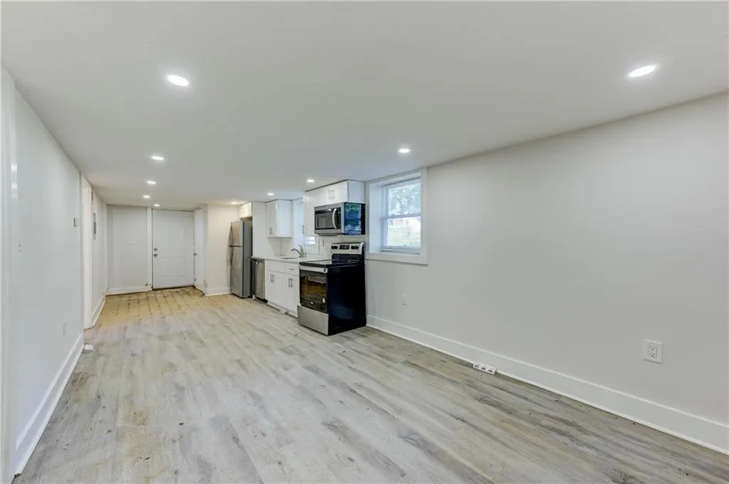 Kitchen with white cabinets, stainless steel appliances, recessed lighting, light countertops, and light wood finished floors