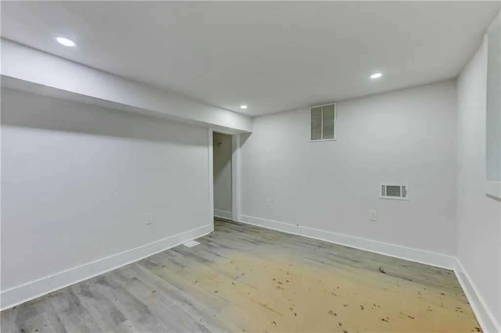 Finished basement with light wood-type flooring and recessed lighting