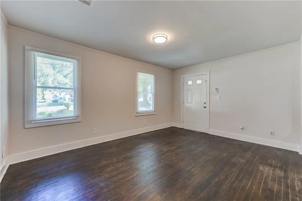 Spare room with dark wood-type flooring and ornamental molding