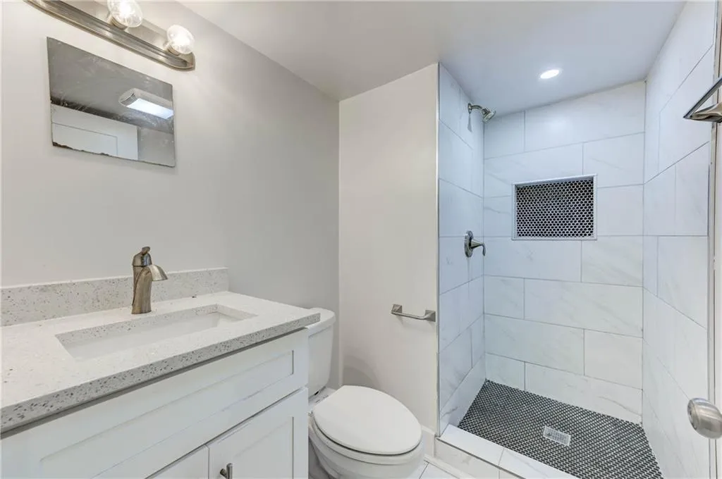 Bathroom with vanity, a shower stall, and recessed lighting