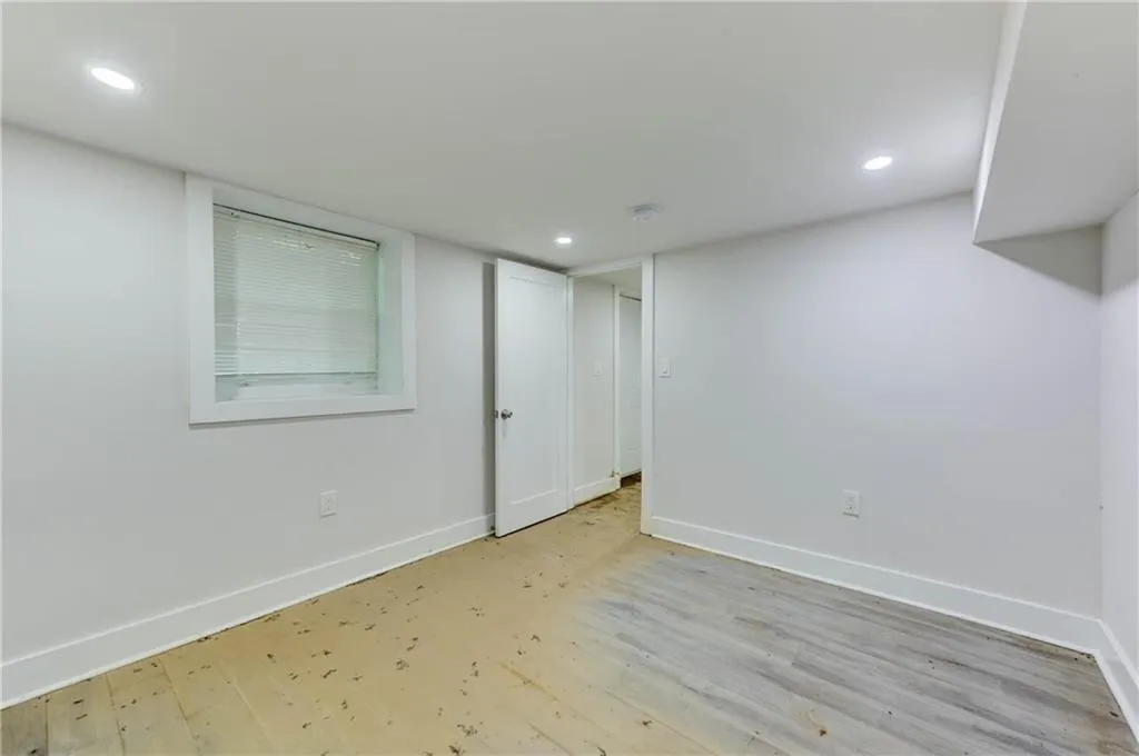 Finished below grade area with light wood-style flooring and recessed lighting