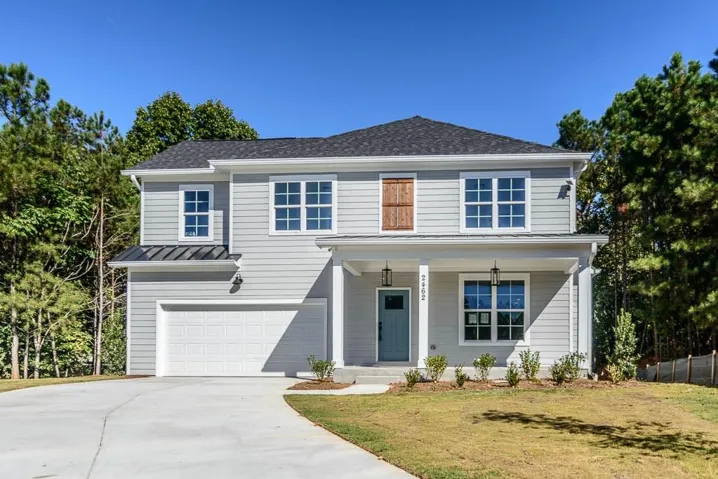 Two-story exterior with light gray siding and a dark shingle roof