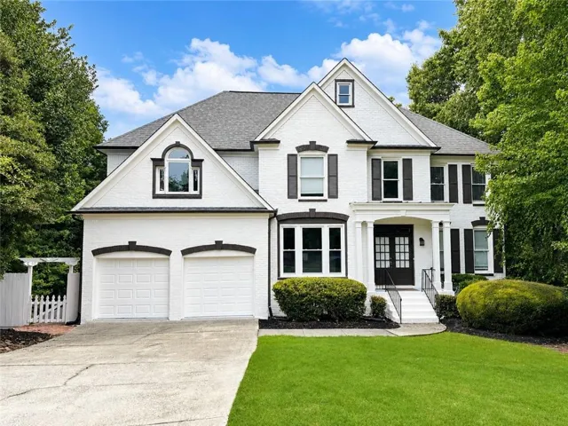 White brick exterior with dark trim and shutters