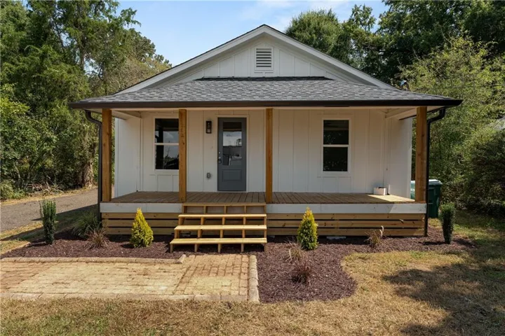 White vertical siding exterior with a dark shingle roof
