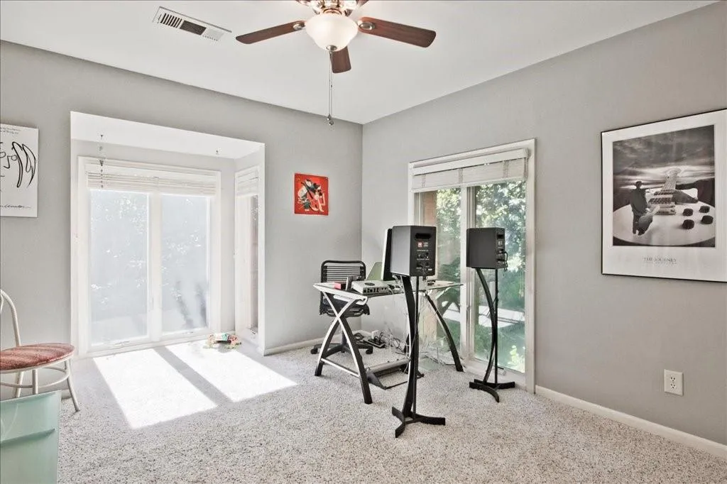 Exercise room with carpet floors and ceiling fan