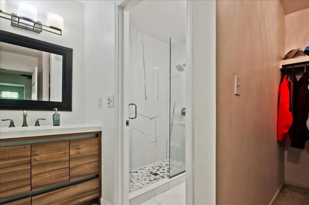 Bathroom with a shower with shower door and vanity