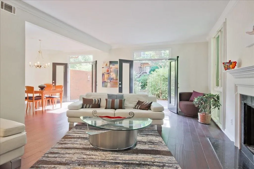 Living room featuring a healthy amount of sunlight, dark hardwood / wood-style flooring, a chandelier, and ornamental molding