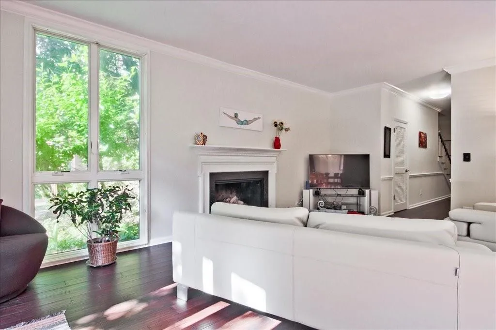 Living room with dark wood-type flooring and crown molding