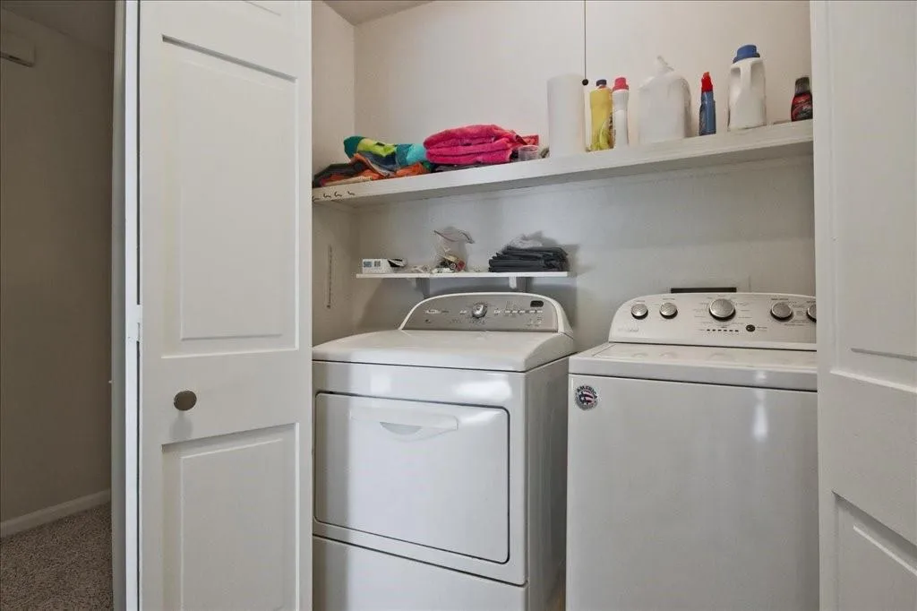 Laundry room featuring washing machine and dryer and carpet flooring