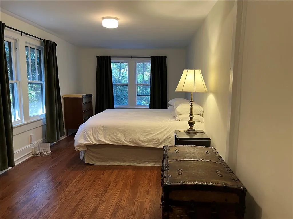 Bedroom with dark wood finished floors and baseboards