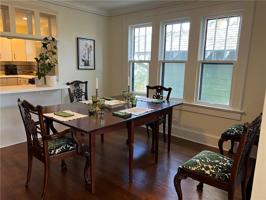 Dining area with dark wood finished floors and ornamental molding