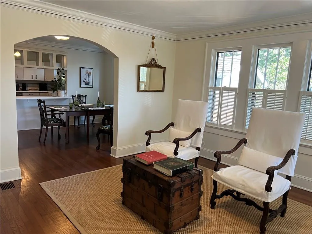 Sitting room featuring crown molding, wood finished floors, and arched walkways