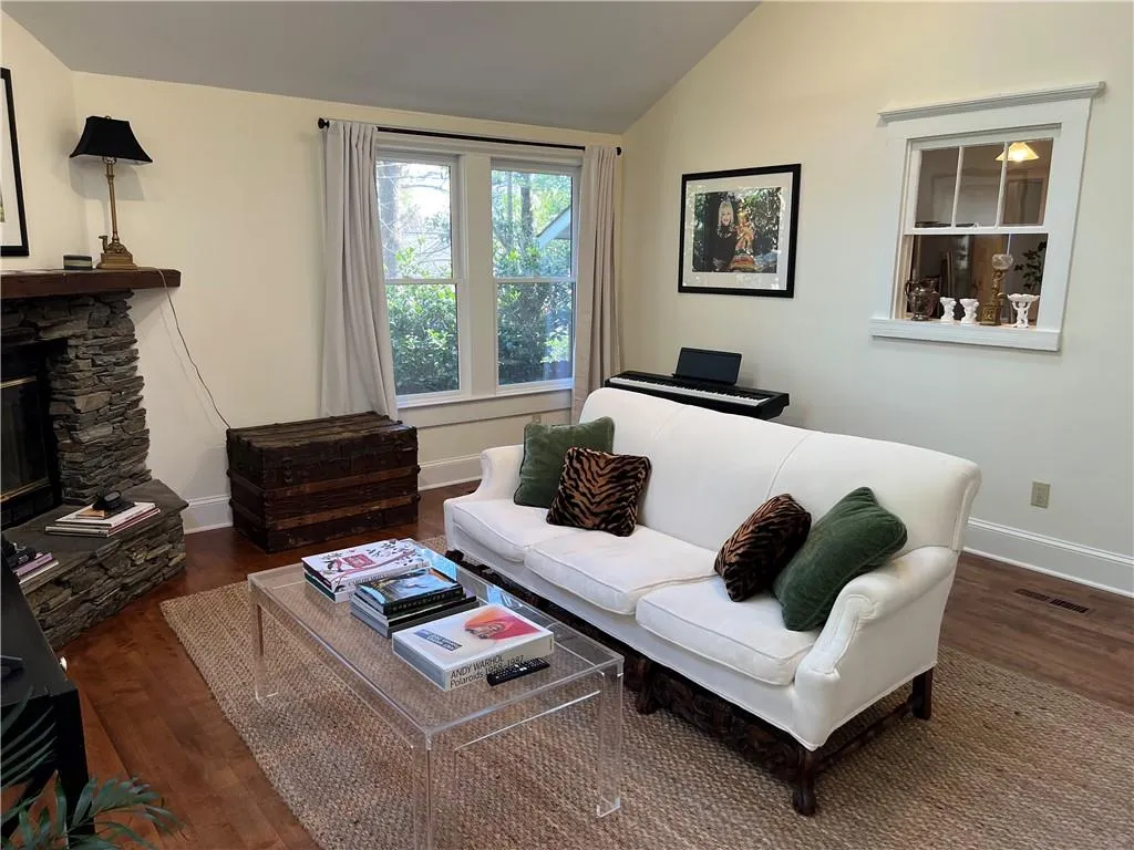 Living area featuring wood finished floors, lofted ceiling, and a fireplace