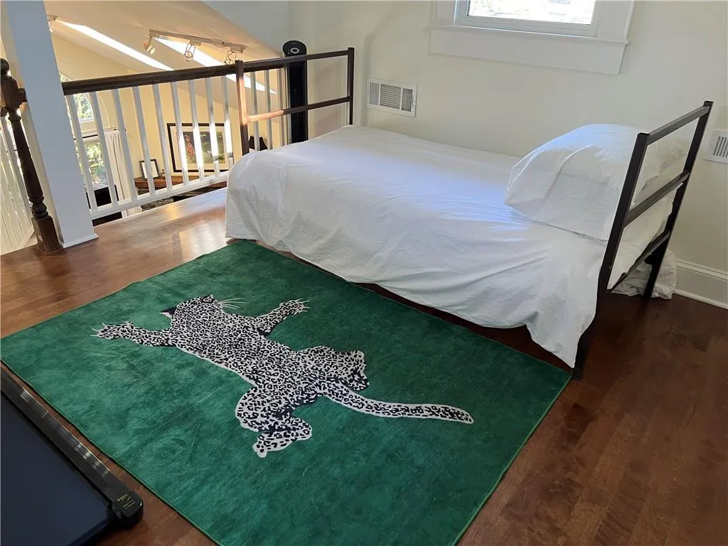 Bedroom featuring wood finished floors and multiple windows