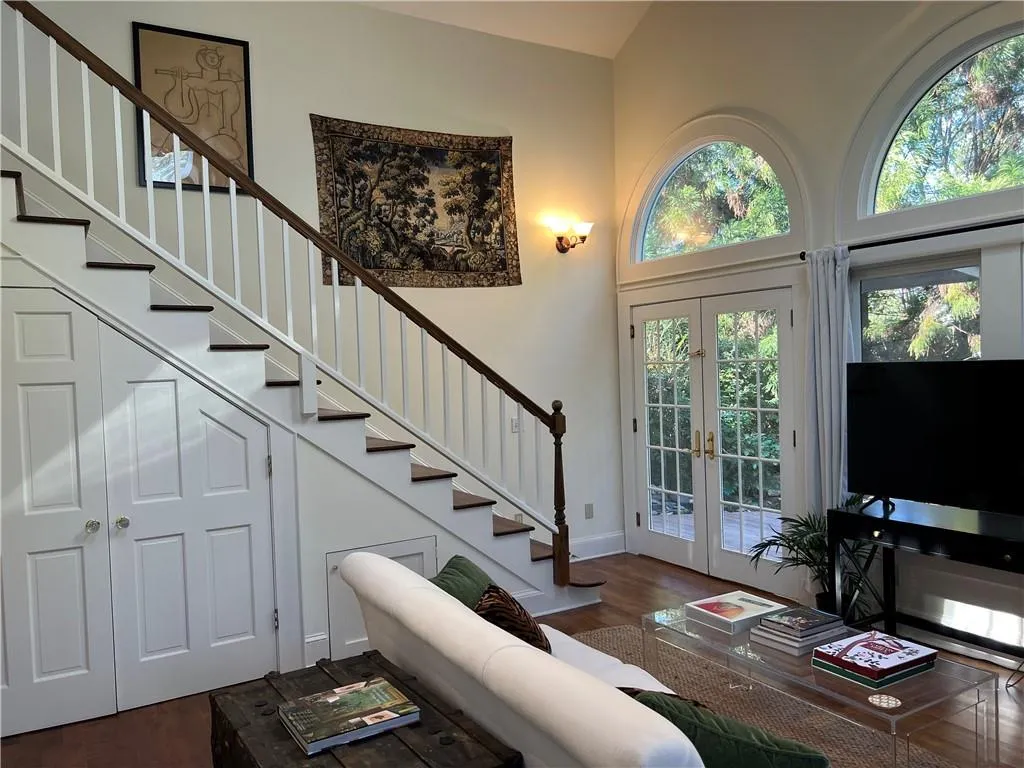 Entryway featuring stairway, french doors, dark wood-style floors, and high vaulted ceiling