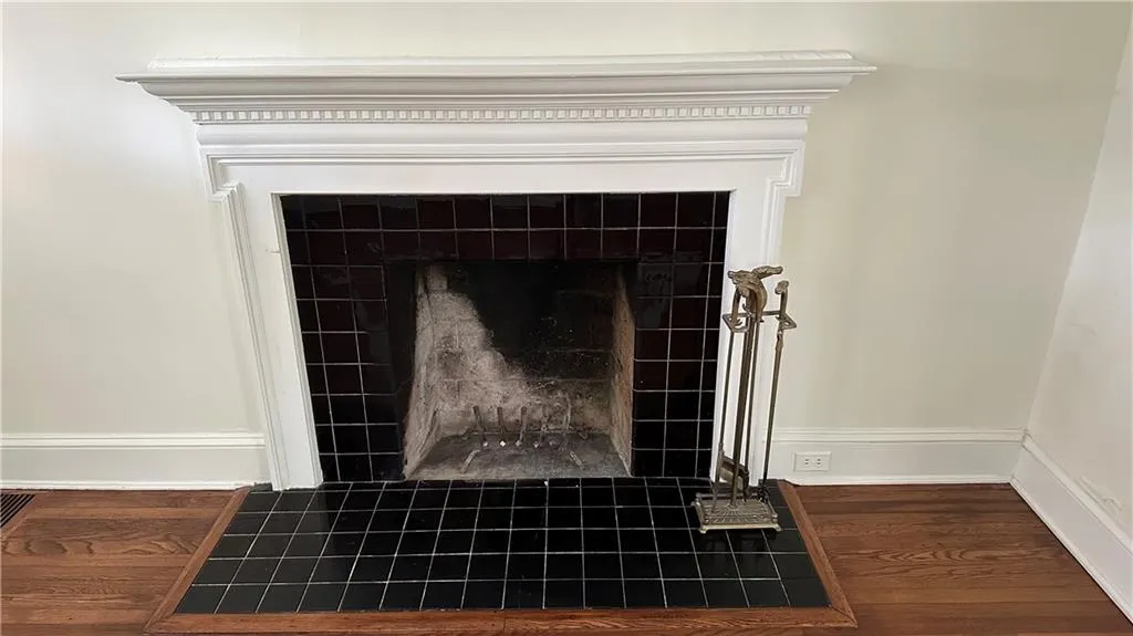 Detailed view of a tiled fireplace and wood finished floors