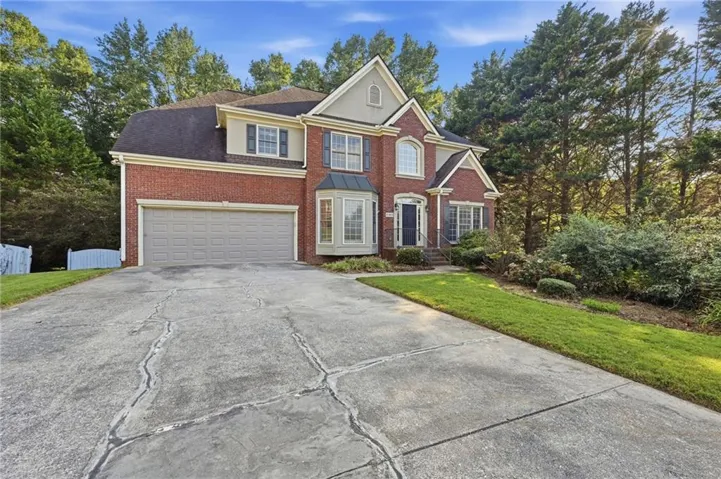 Red brick exterior with light-colored trim and a two-car garage