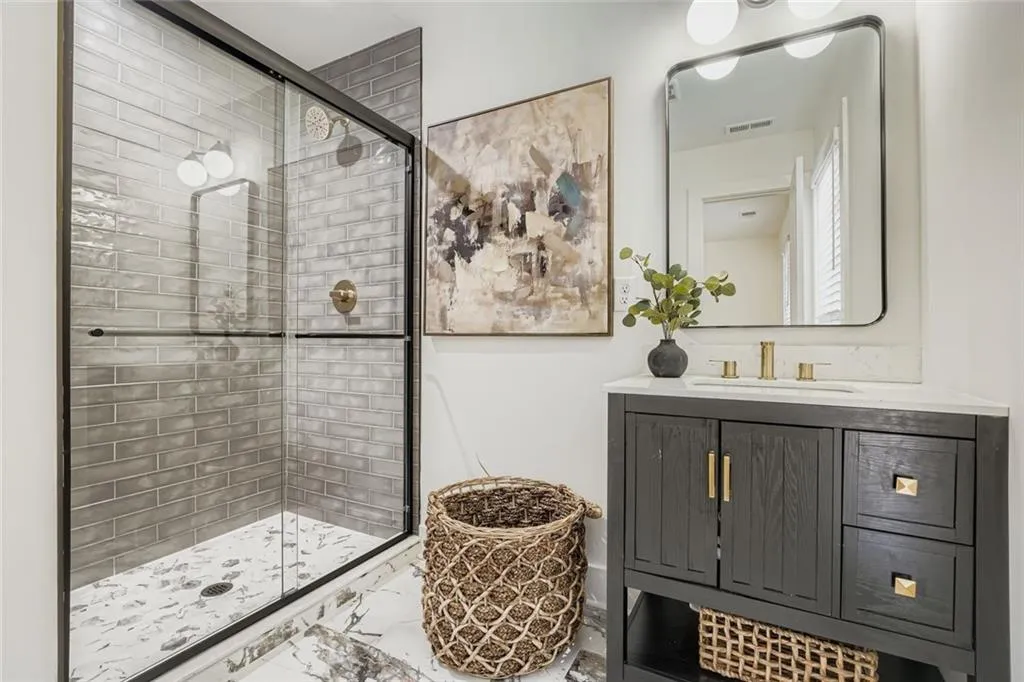 Bathroom featuring vanity, a shower stall, and marble finish flooring