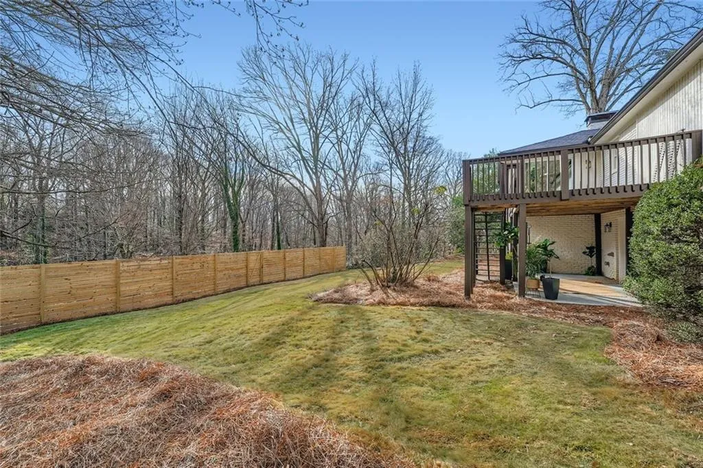 Fenced backyard featuring a patio area, a deck, and stairs