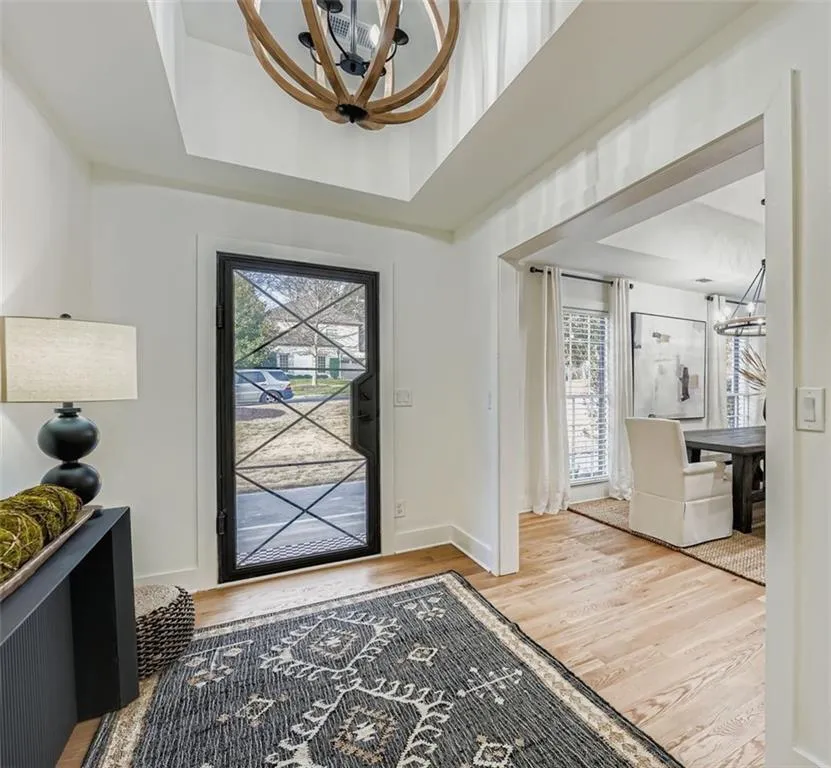 Foyer featuring a chandelier, a tray ceiling, and light wood-type flooring