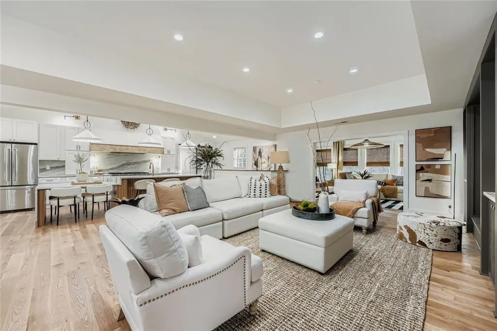 Living area featuring a tray ceiling, light wood finished floors, and recessed lighting