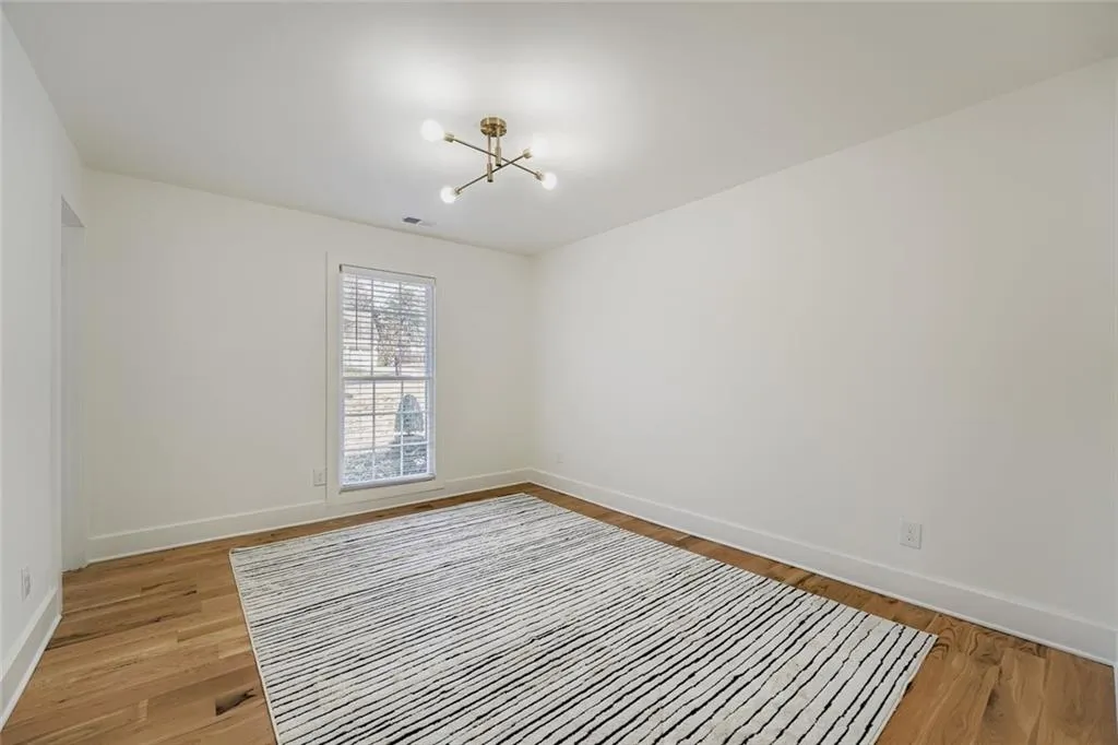 Empty room featuring a chandelier and light wood-style floors