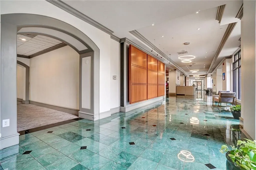Corridor with crown molding, recessed lighting, and arched walkways