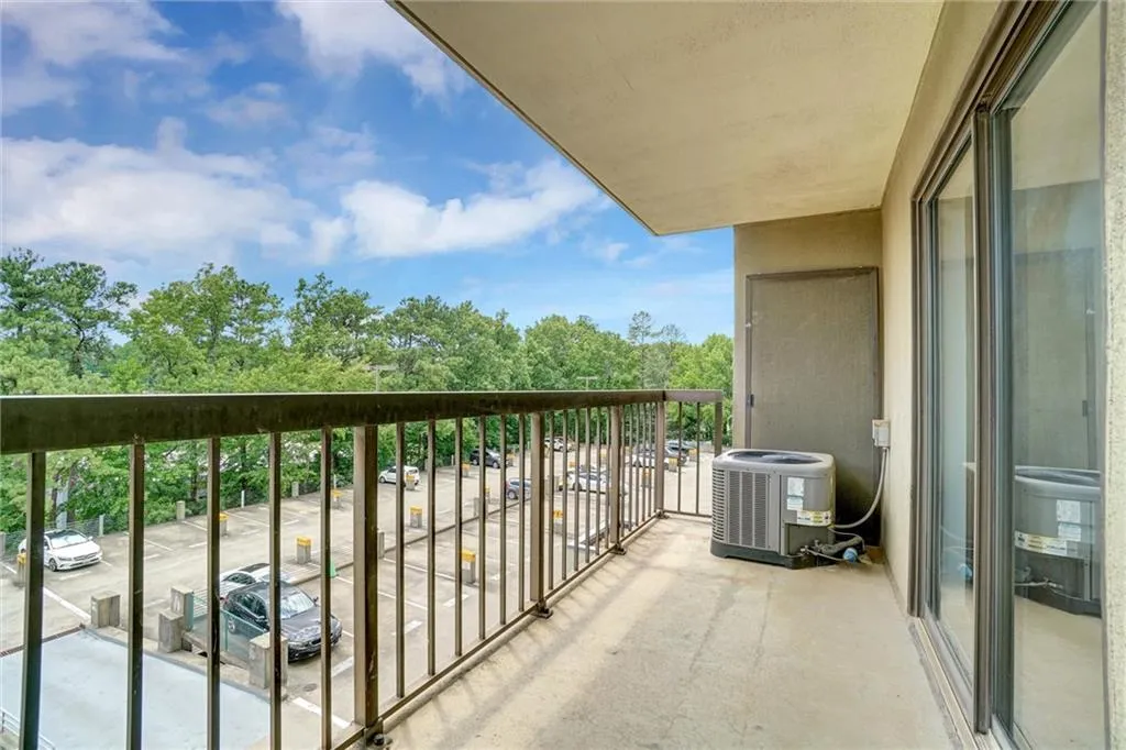 Balcony featuring view of wooded area