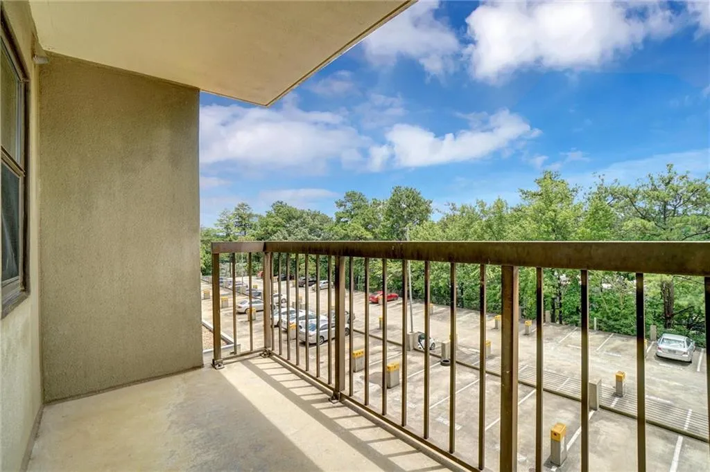 Balcony featuring view of wooded area